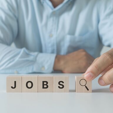 job search concept, find your career. Businessman arranging wooden cube block with jobs lettering on white background.