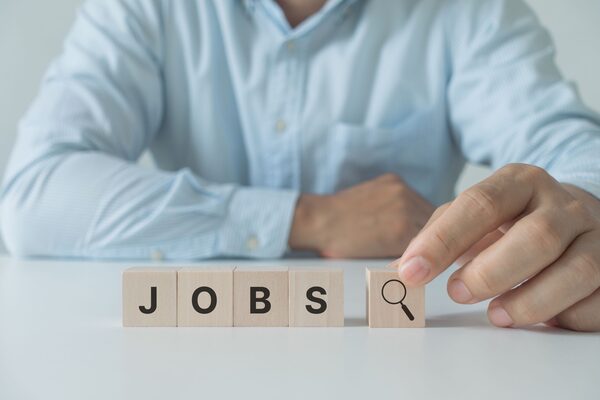 job search concept, find your career. Businessman arranging wooden cube block with jobs lettering on white background.