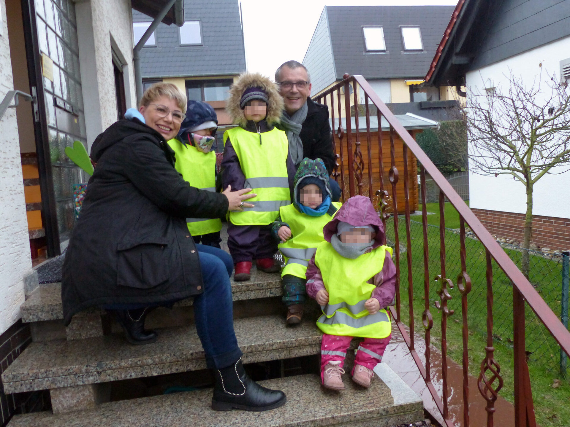 Auf dem Foto sieht man links Tagesmutter Sabine Eisenbrandt und rechts Vizelandrat Andreas Siebert sowie vier Tagespflegekinder mit den Warnwesten.