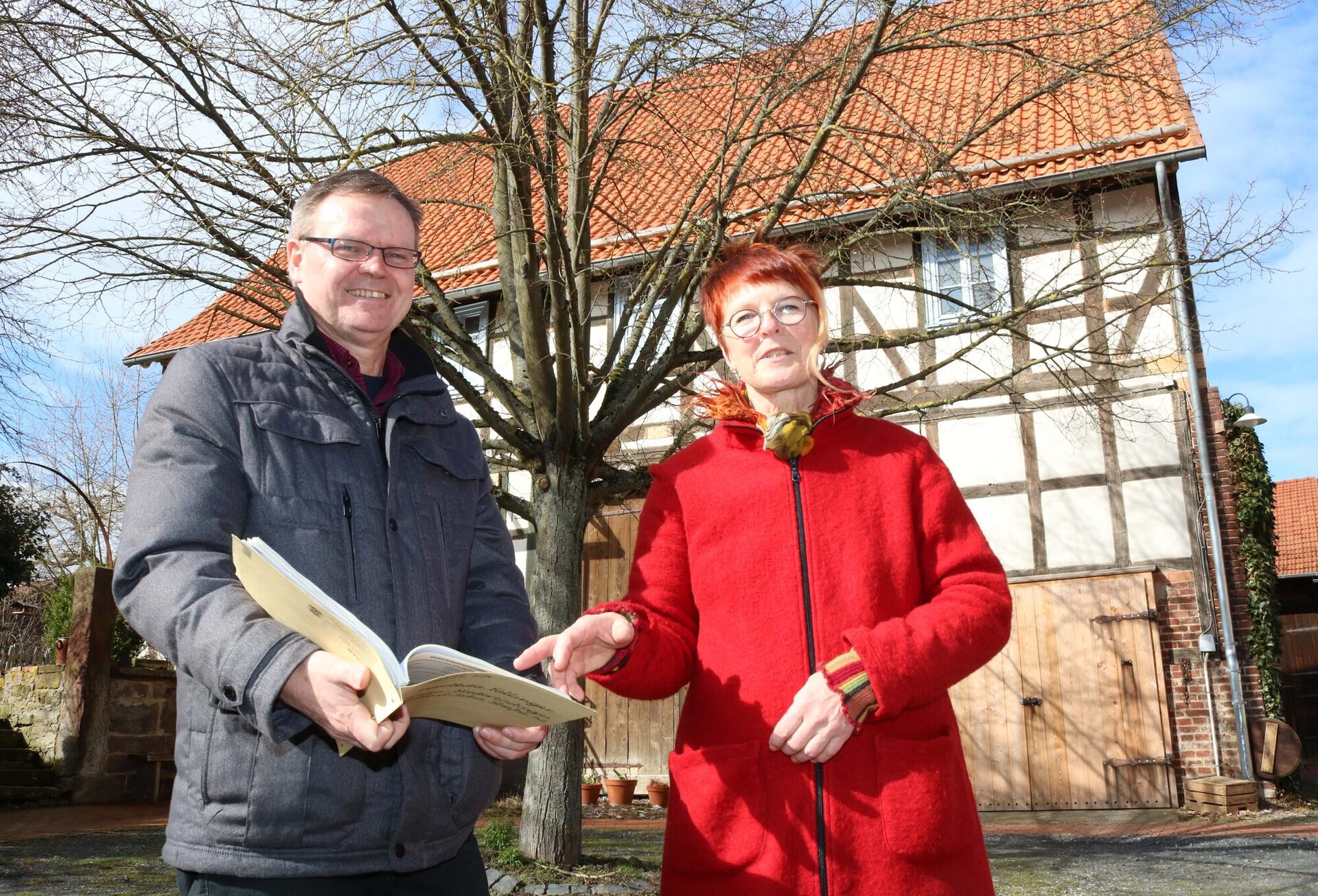Dorothea Fellinger und Dirk Hofmann, Leiter des Fachdienstes Dorf- und Regionalentwicklung, vor der nun sanierten Fachwerkfassade im Ortskern von Niederlistingen.