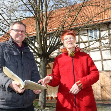 Dorothea Fellinger und Dirk Hofmann, Leiter des Fachdienstes Dorf- und Regionalentwicklung, vor der nun sanierten Fachwerkfassade im Ortskern von Niederlistingen.