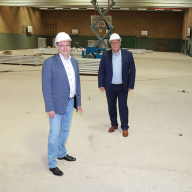 Landrat Uwe Schmidt (links) und Bürgermeister Manfred Ludewig bei der Besichtigung der Sanierungsarbeiten in der Großsporthalle in Vellmar.