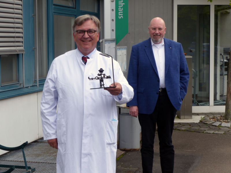 Auf dem Bild sieht man Prof. Dr. Jürgen Faß und Betriebsleiter Silvan Uick vor dem Krankenhaus in Hofgeismar.