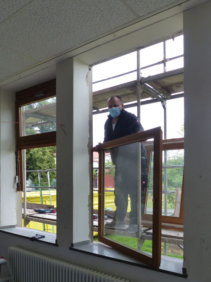 Auf dem Foto sieht man Igor Friesen von der Firma Fenster Walter aus Kassel beim Ausbau der alten Fenster der Wilhelm-Filchner-Schule.