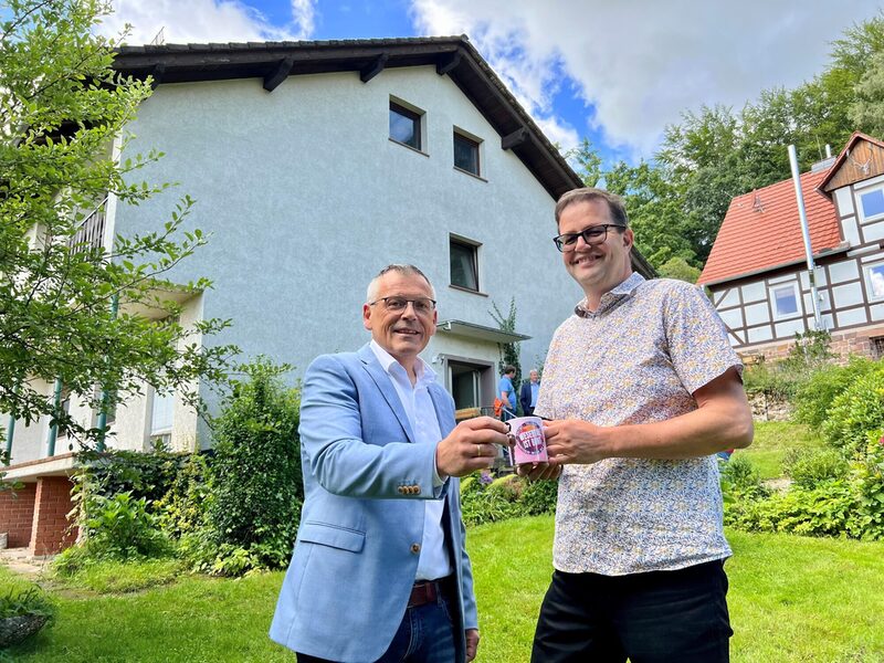 Symbolischer Akt: Landrat Andreas Siebert und Wesertals Bürgermeister Cornelius Turrey tauschen den Schlüssel für das Haus am Mühlenplatz 7 gegen eine Wesertal-ist-Bunt-Kaffeetasse.