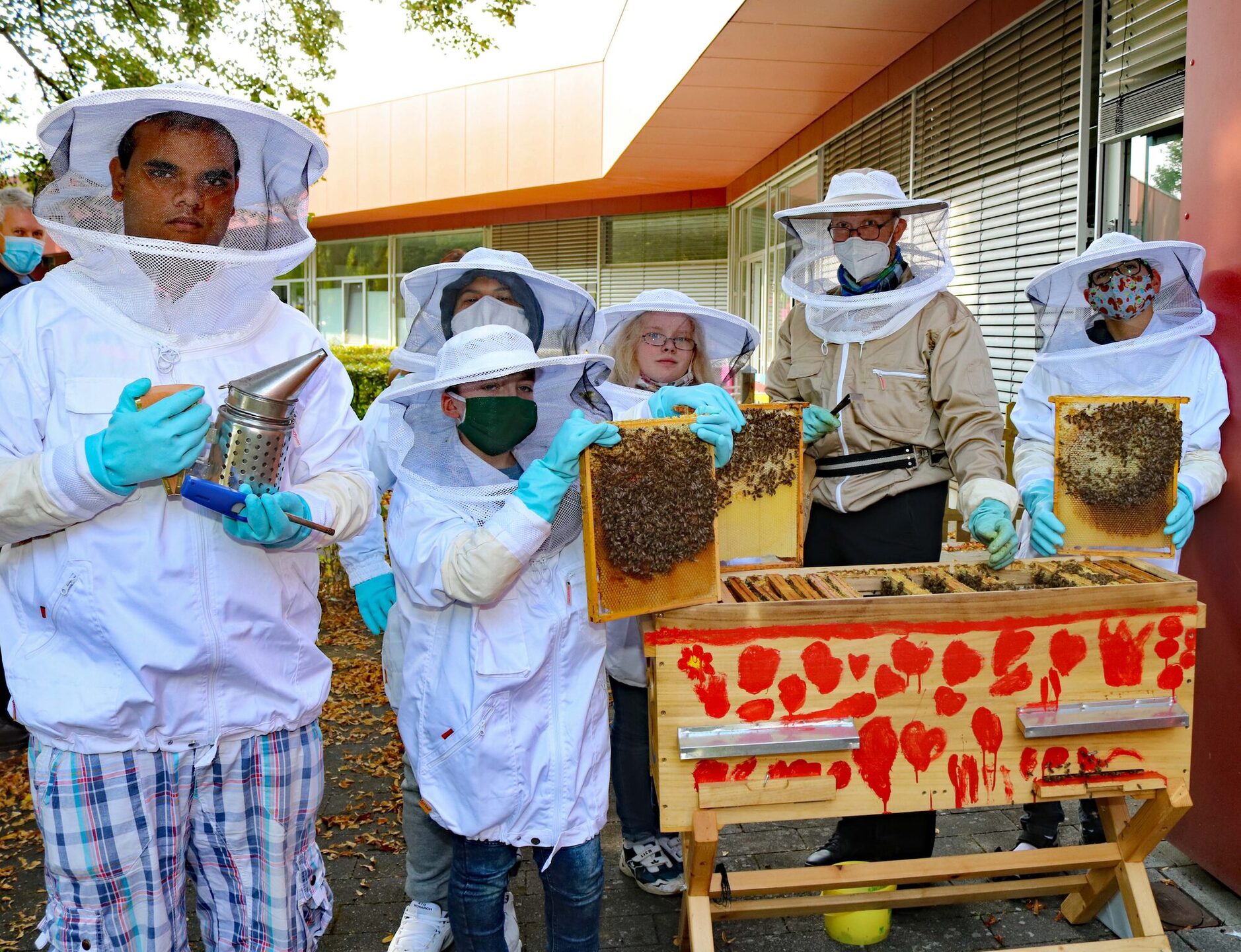 Die Schüler Shamin (17), Marcel (17), Mathilda (11), Lennard (11) und Haskan (17) versorgen gemeinsam mit Jörg Heiderich die Bienen.