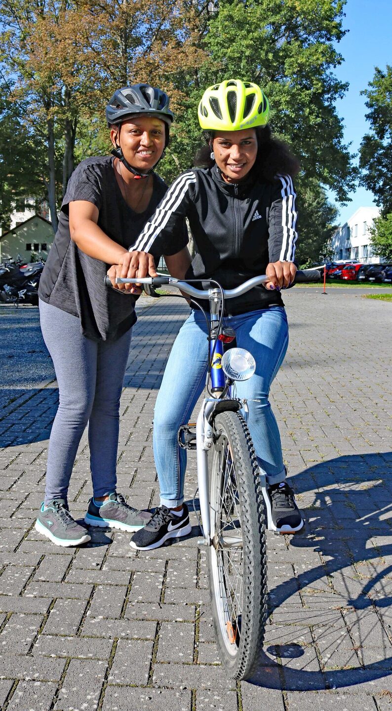 Awatash Lema übt das Radfahren. Ihre Freundin Kibret Hagdu hilft.
