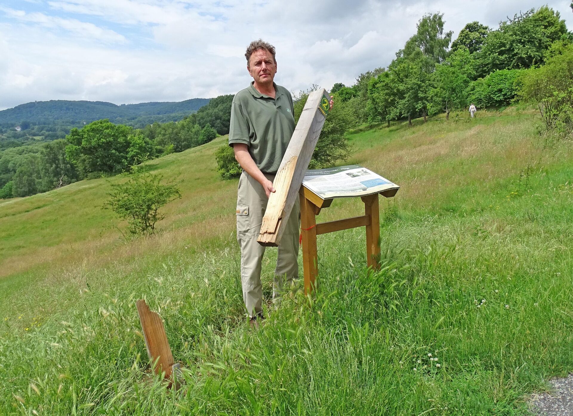 Jürgen Depenbrock, Geschäftsführer des Zweckverbandes Naturpark Habichtswald, mit einem mutwillig zerstörten Wegweiser.
